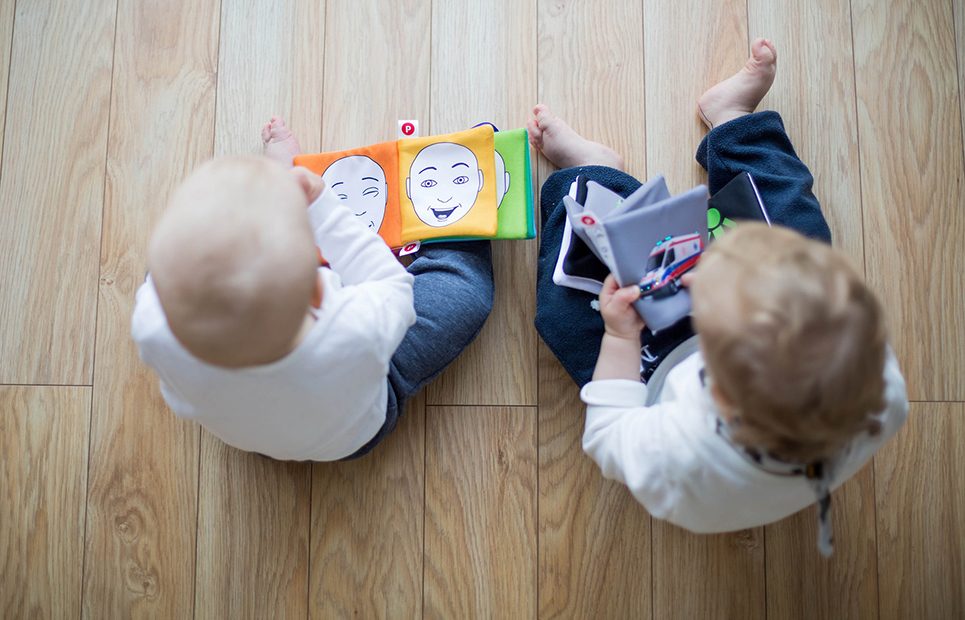 Zwei Kleinkinder betrachten Bücher