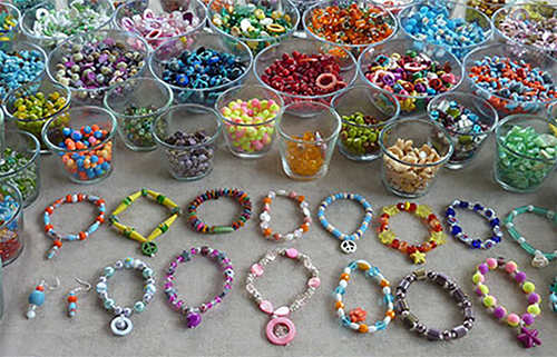 Perlenbänder und Schalen mit vielen verschiedenen bunten Perlen